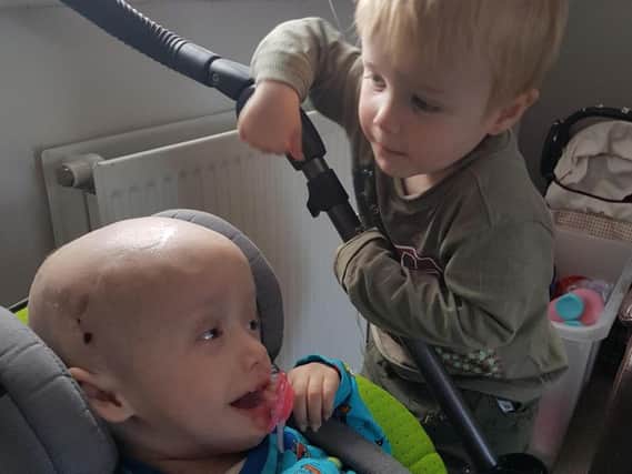 An adorable video shows the moment Robert helpfully gives his twin his dummy as he sits in his specialised chair, while another shows considerate Robert passing his brother a bottle of juice.