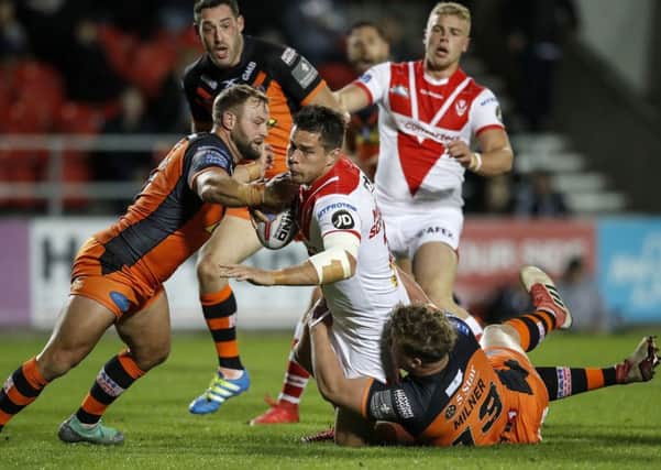 St Helens' Louie McCarthy-Scarsbrook is tackled by Castleford Tigers duo Paul McShane (left) and Adam Milner.