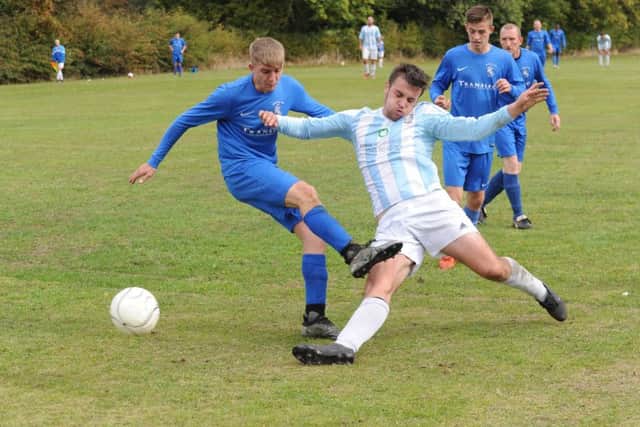 Haydn Bowler, of FC Armley Sundays, shoots as The Woodcock AFC's Danny Alcock tries to block. PIC: Steve Riding