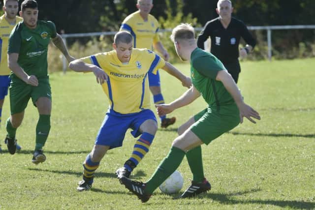 Ben Keedy, of Gidersome Spurs OB, takes on Beeston St Anthony's Danny Norton. PIC: Steve Riding