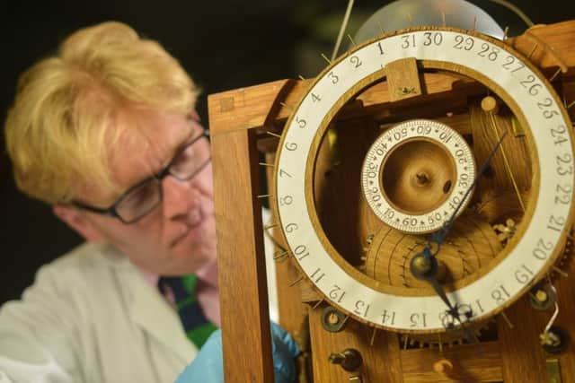 Conservator Matthew Read repairs a replica of the 18th Harrison Clock, in Leeds City Museum. PIC: SWNS