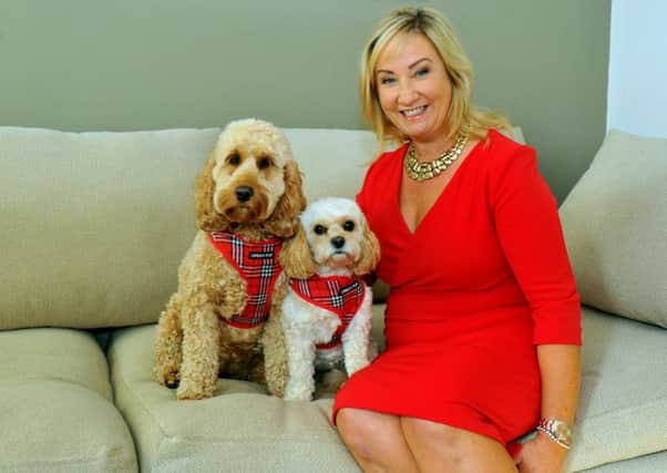 Jackie wears the Diana dress in red, at home with her dogs  Maisie (lef) and Mollie. Picture by Gary Longbottom.