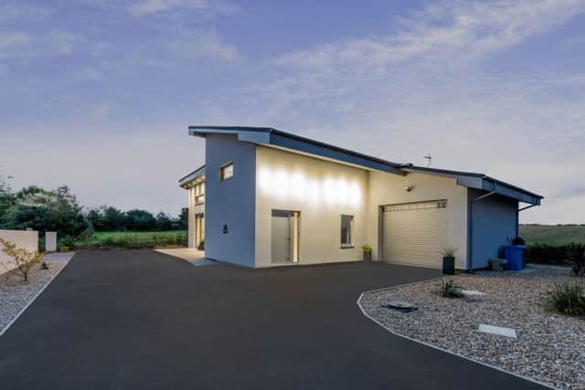 The side elevation with garage and showing the roof with built-in solar tiles.