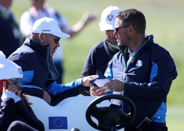 Team Europe captain Thomas Bjorn and vice-captain Lee Westwood look at notes during the Ryder Cup at Le Golf National, Paris. Picture: David Davies/PA