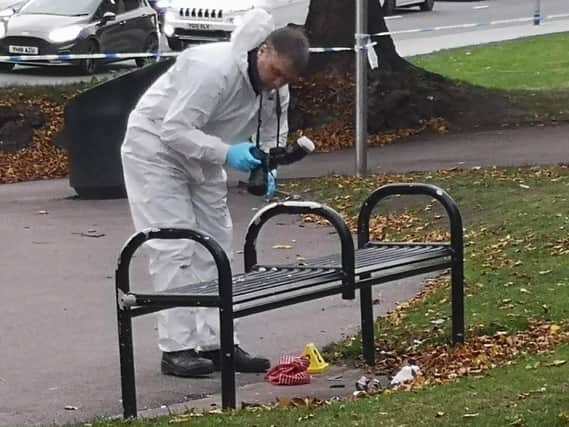 Forensics officers examine the scene at Lovell Park, Leeds, where a 16-year-old boy was stabbed