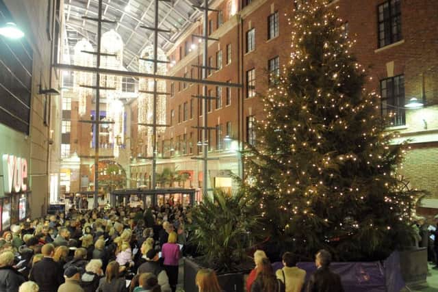 Members of the public singing carols around the lit Chritmas Tree at the Yorkshire Evening Post Half and Half Appeal  Light Up A Life at The Light in Leeds .