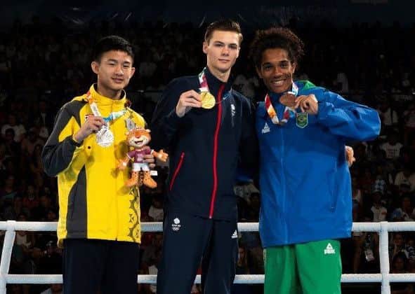Leeds boxer Hope Price, centre, shows off his gold medal at the Youth Olympics.