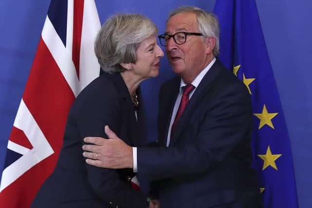 British Prime Minister Theresa May, left, hugs Jean-Claude Juncker, President of the European Commission, as they meet in Brussels. (AP Photo/Francisco Seco)