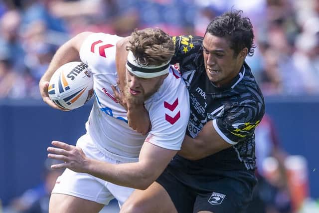 Engkand's Elliott Whitehead is tackled by New Zealand's Te Maire Martin.
