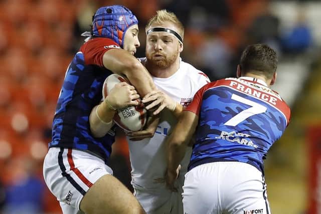 England's Oliver Holmes is tackled by France's Benjamin Jullien (left) and William Barthau.
