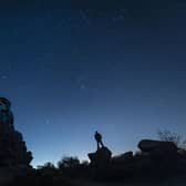 A plane and a Satellite pass by as a man stargazes at Brimham Rocks in Yorkshire as the Orionid meteor shower reaches its peak. PRESS ASSOCIATION Photo.
