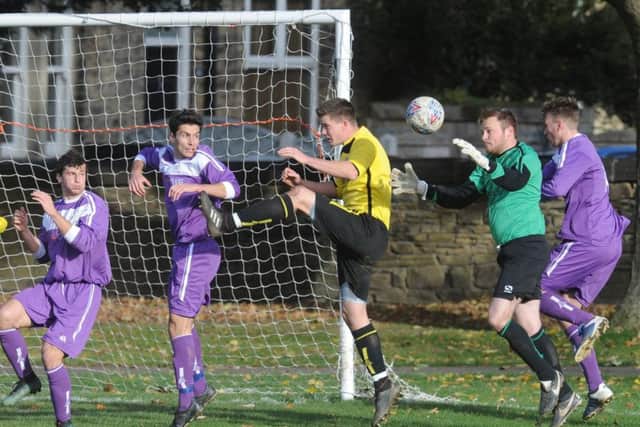 Jack Mills, of Calverley, looks for a loose ball as Medics' goalkeeper Tim Griffiths collects. PIC: Steve Riding