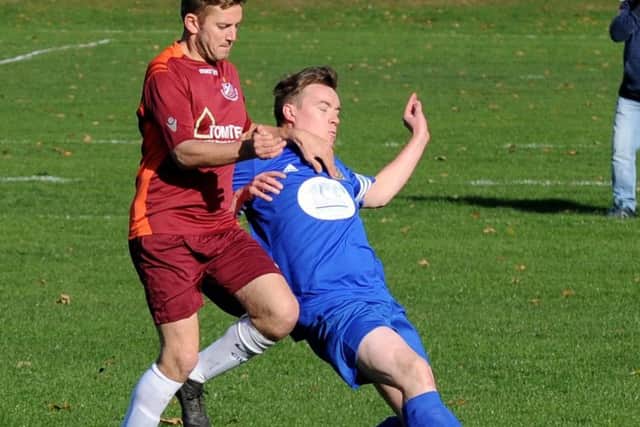 Tom Franklin, of Bardsey Sunday, gets to grips with John Brook of Acorn (Bramley) FC. PIC: Steve Riding