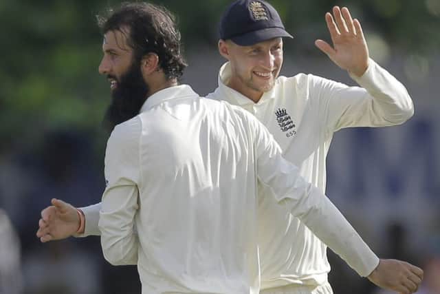 England's Moeen Ali, left, and Joe Root celebrate the wicket of Sri Lanka's Niroshan Dickwella in Galle. Picture: AP/Eranga Jayawardena