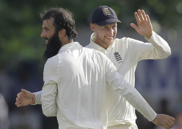 England's Moeen Ali, left, and Joe Root celebrate the wicket of Sri Lanka's Niroshan Dickwella in Galle. Picture: AP/Eranga Jayawardena