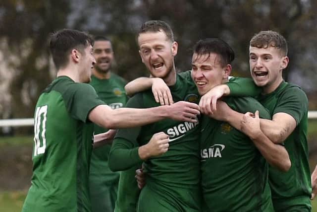 Beeston St Anthony's goal scorer Reece Farnhill is swamped by team-mates following his goal in the 3-1 Premier Division win over Leeds City. PIC: Steve Riding