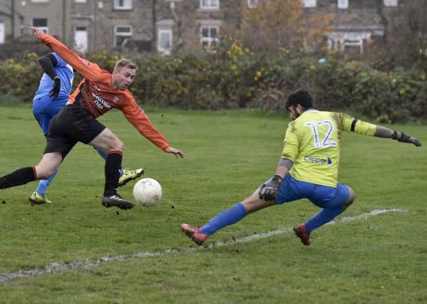 James Tessieman, of Woodkirk, has his shot stopped by Whitkirk Wanderers goalkeeper Jordan Leatham. PIC: Steve Riding