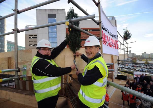 Topping out ceremony for the new Maggies Centre, at St James Hospital, Leeds.. John Greenoff (left) and Dr Terry Bramall nail the fern to mark the topping out ceremony.
