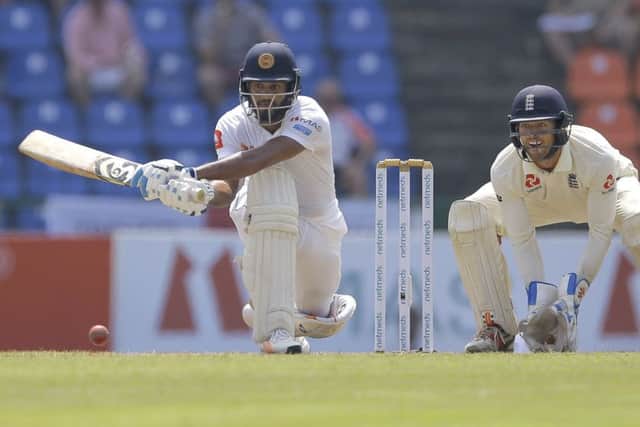 Sri Lankan Dhananjaya de Silva plays a shot as England's wicketkeeper Ben Foakes watches during the second day of the second test cricket match between in Pallekele. Picture: AP/Eranga Jayawardena.