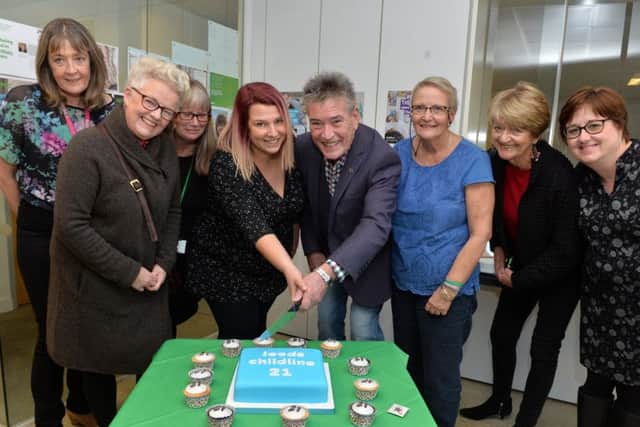 King of Bradford Panto, Billy Pearce helps Leeds Childline base celebrate 21st anniversary pictured cutting the cake with Sam Firth, Child line Supervisor.