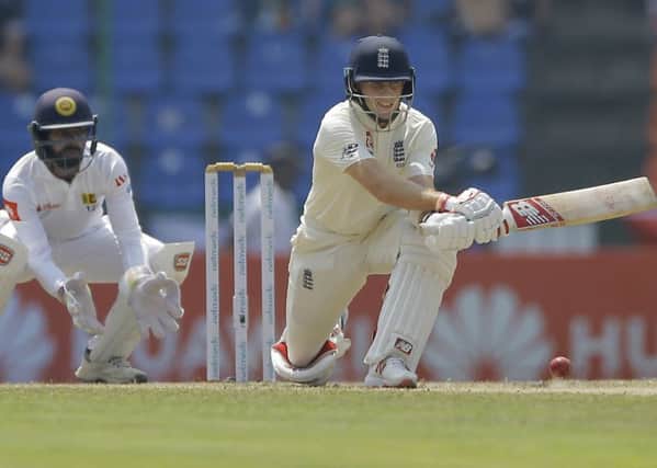 Captain Joe Root, right, plays a reverse sweep on his way to posting a fourth overseas Test century for England, against Sri Lanka in Pallekele. Picture: AP/Eranga Jayawardena