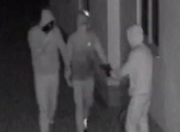 The three suspects with the gun outside the couple's home.