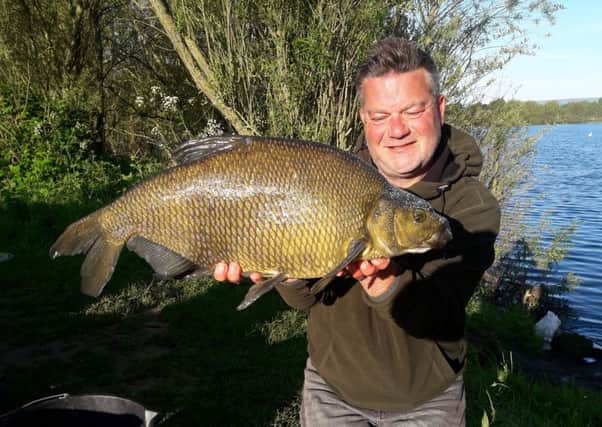 Darren Starkey peeps over the shoulders of a near-12lb Knotford bream. The new keepnet ban should keep these fish in perfect condition.