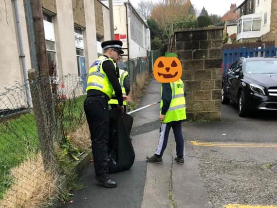 Police made the youths pick litter in the street. Photo: West Yorkshire Police