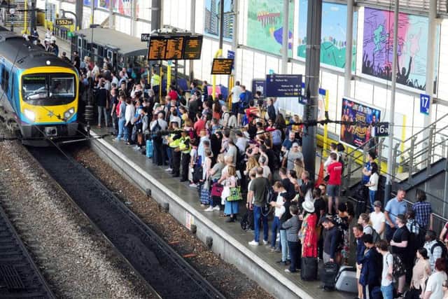 Passengers in Leeds await the arrival of a service to Manchester.