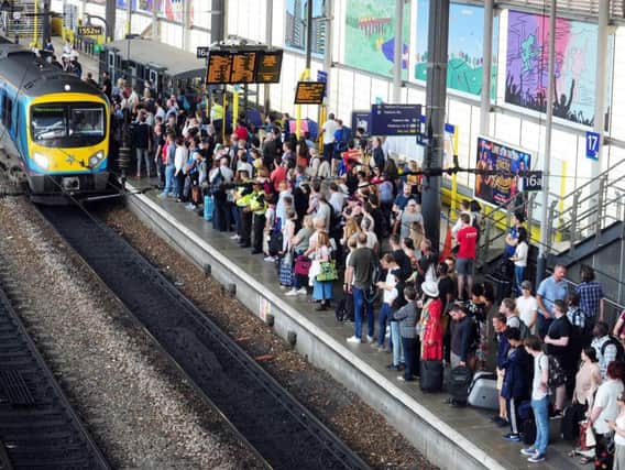 Passengers in Leeds await the arrival of a service to Manchester.