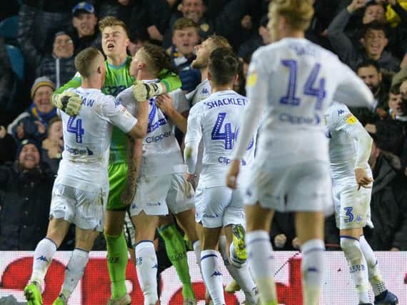 Leeds United's players mob Bailey Peacock-Farrell after his penalty save against Reading.