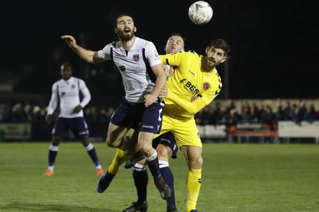 Guiseley's Alex Purver and Fleetwood Town's Ched Evans battle for the ball.