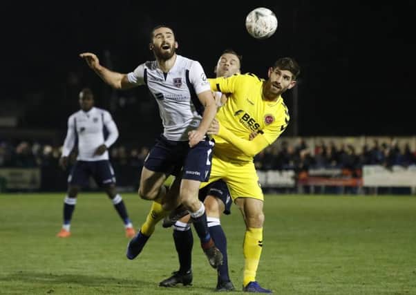 Guiseley's Alex Purver and Fleetwood Town's Ched Evans battle for the ball.