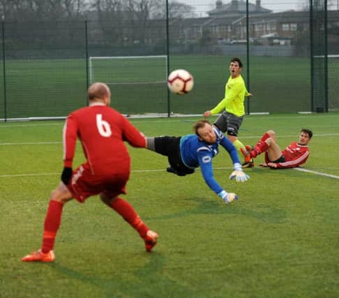 Shire goalkeeper James Webber tips away this shot from Antony Wilson of Gildersome Spurs OB. PIC: Steve Riding