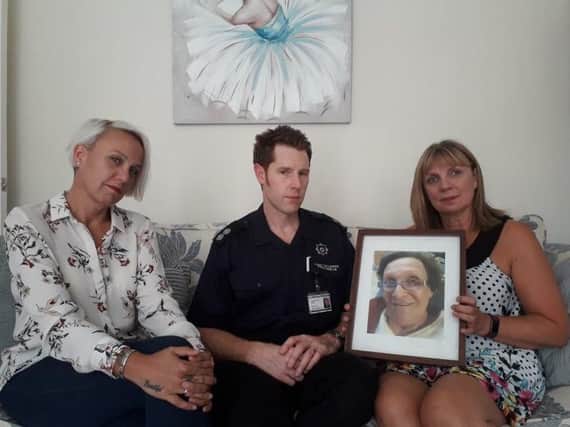 A  West Yorkshire Fire and Rescue Service representative with members of Pauline Taylor's family with a photograph of her.