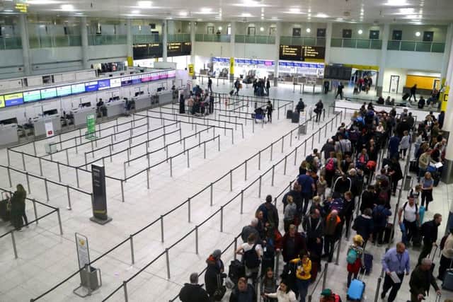 Passengers queue for flights at Gatwick Airport as the airport and airlines work to clear the backlog of flights delayed by the drone incident. PIC: PA