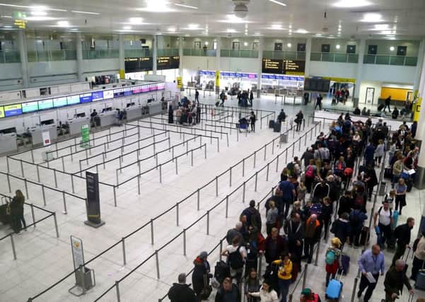 Passengers queue for flights at Gatwick Airport as the airport and airlines work to clear the backlog of flights delayed by the drone incident. PIC: PA
