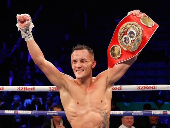 Josh Warrington holds aloft his IBF featherweight title after his pulsating victory over Carl Frampton.