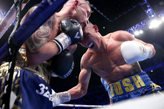 Carl Frampton is pinned up against the ropes by Josh Warrington during their title bout in Manchester.