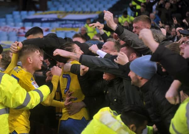 Leeds captain Luke Ayling (right) and goalscorer Jack Clarke dive into the fans to celebrate Kemar Roofe's late, late winner. PIC: Tony Johnson