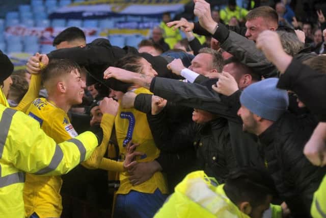 Leeds United's players celebrate with the travelling fans following late winner.