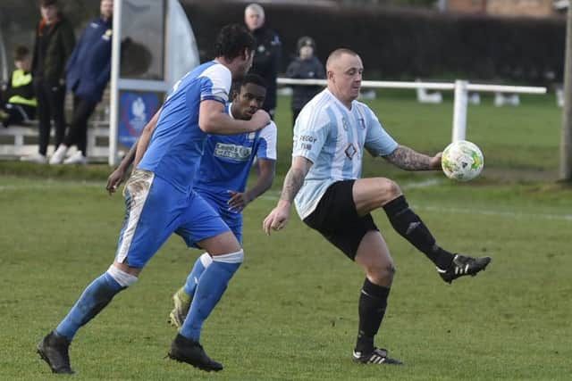 Scott Hargreaves of Carlton Athletic is first to the ball against Whitkirk Wanderers.