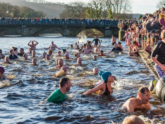 Crowds of onlookers watch on as hardy locals take part in the annual New Year's Day dip at Otley.