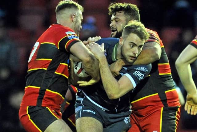 Dewsbury's Tom Garratt and Jordan Andrade combine to stop Featherstone Rovers's Daniel Waite-Pullan in their Yorkshire Cup clash. Picture Tony Johnson.