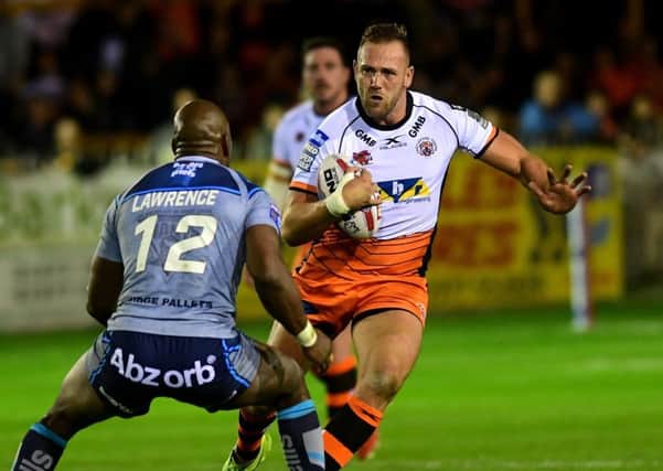 Liam Watts is tackled by Huddersfield's Michael Lawrence.