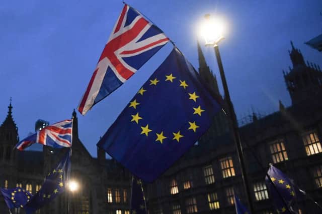 Protesters with Union Flags and EU flags are seen outside the Houses of Parliament in central London on January 15, 2019. - Parliament is to finally vote today on whether to support or vote against the agreement struck between Prime Minister Theresa May's government and the European Union. (Photo by Paul ELLIS / AFP)        (Photo credit should read PAUL ELLIS/AFP/Getty Images)