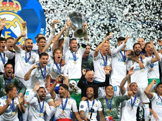 MAKE MINE A TREBLE: Real Madrid captain Sergio Ramos, with trophy, celebrates a third Champions League triumph in a row with new Leeds United recruit Kiko Casilla, bottom left.