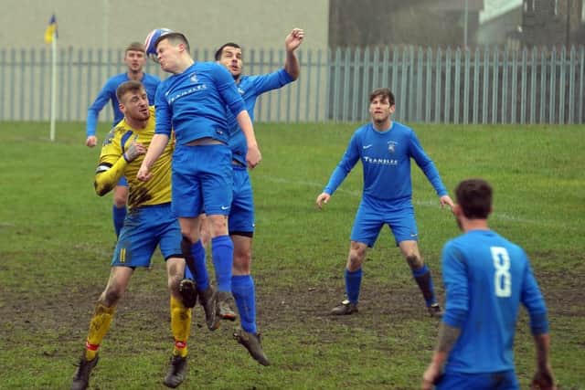 Woodcock's Andrew Roebuck does enough to glance the ball away from Rodley's Jordan Heyes. PIC: Tony Johnson
