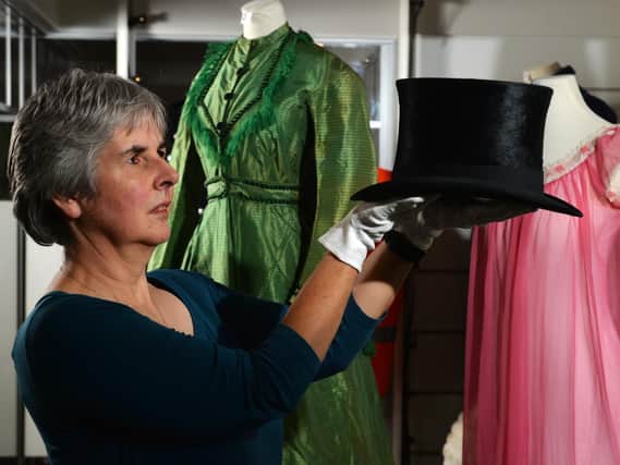 Danger Zone, a new exhibition which opens at Kirkstalls Abbey House Museum later this week, explores some of the surprising everyday threats that were hiding in plain sight in homes and workplaces over the past 150 years. 
Social History Curator Kitty Ross with a dapper-looking top hat containing mercury, a common material used when the headgear was made in around 1840.