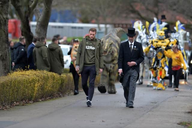 Leeds United's Liam Cooper leads the cortege in front of Trixie the dinosaur and Power Ranger BumbleBee . Toby Nye funeral at Cottingley Crematorium.